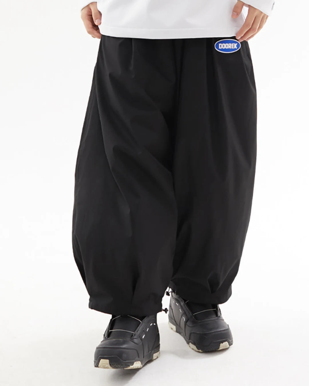 Black baggy ski trousers paired with a white top and black winter boots, showcasing a relaxed fit