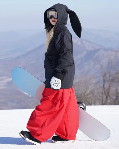 Close-up of red winter trousers highlighting the wide-leg design and snow-ready features