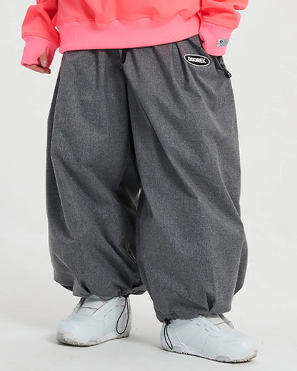 Close-up of grey loose-fit trousers styled with a pink sweatshirt and white sneakers